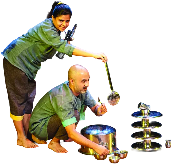 Two performers with a ladle, a steel pot and a tower of stacked steel plates.
