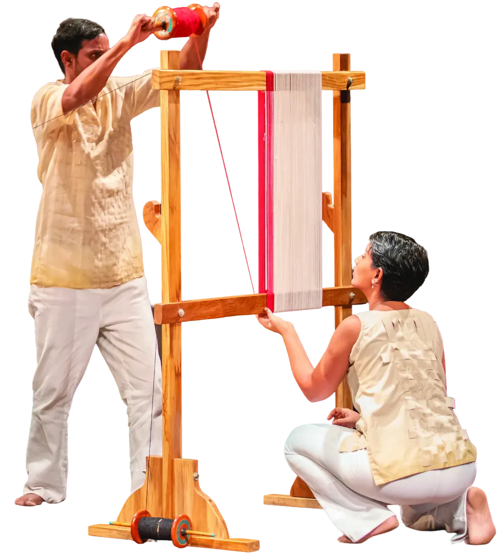Two performers working at a tall wooden hand loom.