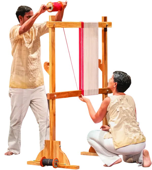 Two performers working at a tall wooden hand loom.