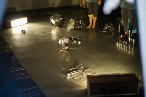 A performer gathers the vessels together at the end.